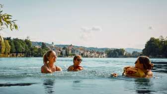 Personen schwimmen im Rhein mit dem Wickelfisch