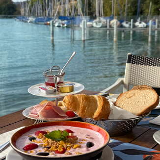 Fruehstueck mit Beerenmuesli, Croissant und Brot direkt am Hallwilersee bei der Schifflaende Birrwil.