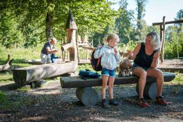 Familie erkundet den Erlebnisweg "Aarauer Waldabenteuer". Hier beim Pick.Nick an einer Feuerstelle.