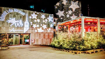 Festlich beleuchtete WunderBar in Aarau mit Weihnachtsbäumen, leuchtenden Sternen und Lichtprojektionen an den Gebäudefassaden.