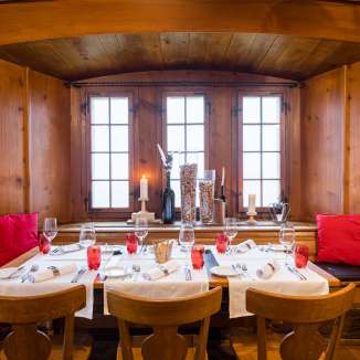 Festlich gedeckter Esstisch in einer historischen, holzgetäfelten Gaststube des Schlossrestaurants Habsburg.