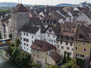 Postauto fährt über Aare-Brücke aus der Altstadt Brugg.