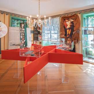 Historischer Ausstellungsraum im Hexenmuseum mit roten Vitrinen, Exponaten und Informationstafeln zur Geschichte der Hexenverfolgung