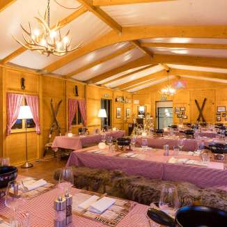 Gemuetlich eingerichtetes Fondue-Restaurant Zollhuus mit gedeckten Tischen und rustikaler Chalet-Atmosphaere.