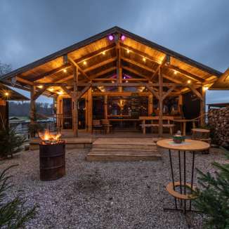 Beleuchtete Holzhütte im Winterdorf auf dem Rütihof mit Feuerstelle und gemütlicher Atmosphäre.