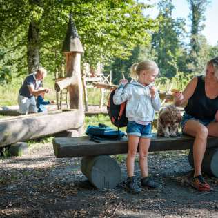 Familie erkundet den Erlebnisweg "Aarauer Waldabenteuer". Hier beim Pick.Nick an einer Feuerstelle.