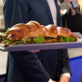 Grosses, knuspriges Croissant mit frischem Salat und herzhafter Füllung, serviert auf einer Platte im TYDE im FORTYSEVEN in Baden..