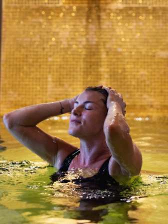 eine Frau badet in der Therme des Limmathof Spa's.